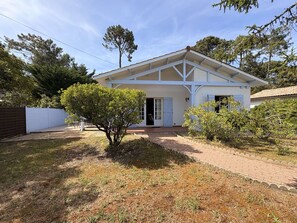 A two-story house with a covered porch, a small garden, and a fenced yard. - Calm villa in Cap-Ferret - 7 guests (Lège-Cap-Ferret)