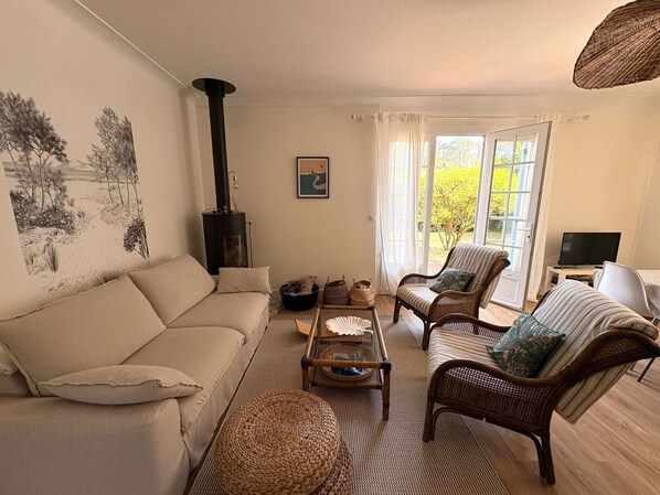 A cozy living room with a sofa, two armchairs, a coffee table, a fireplace, and a television. - Calm villa in Cap-Ferret - 7 guests (Lège-Cap-Ferret)