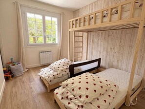 A bunk bed room with two beds, a window, and a radiator. - Calm villa in Cap-Ferret - 7 guests (Lège-Cap-Ferret)