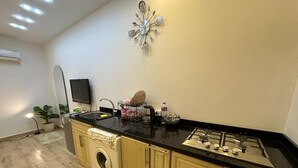 Une cuisine équipée d’un lave-linge, d’un évier, d’une cuisinière et d’un élément décoratif mural.