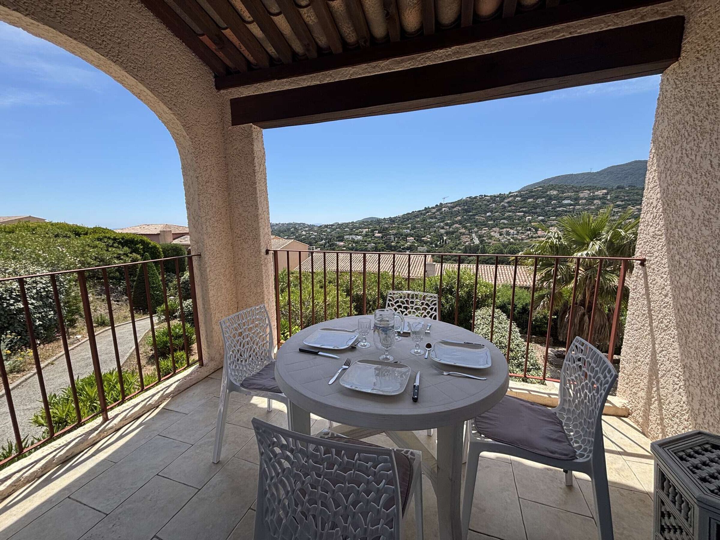 Une table ronde entourée de chaises, installée sur une terrasse et offrant une vue sur un paysage magnifique.