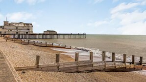 A coastal beach with a wooden jetty, a pier, and a building with a flat roof. - Spacious Flat with Gorgeous Views - Pass the Keys (Bognor Regis)