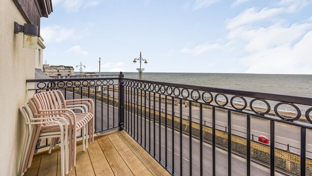 A balcony with chairs, a railing, and a view of the sea. - Spacious Flat with Gorgeous Views - Pass the Keys (Bognor Regis)