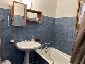 Ein Badezimmer mit Waschbecken, Spiegel und Badewanne.
