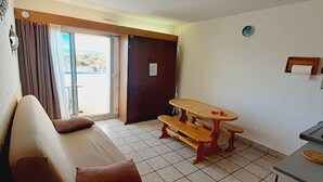 A room with a sofa, a small table, and a bench.