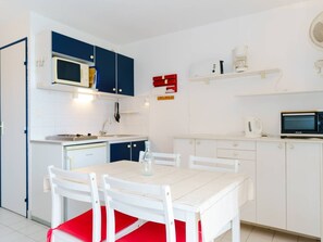 Eine kleine Küche mit Mikrowelle, Kaffeemaschine und kleinem Kühlschrank.