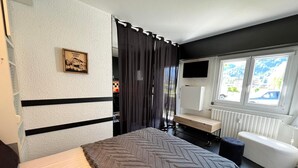 Makuuhuoneessa on sänky, työpöytä, tuoli, televisio ja ikkuna, josta on näkymä.
