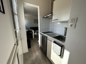 Una cocina compacta con lavavajillas, pileta doble y estufa.