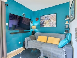 Ein Wohnzimmer mit Fernseher, Sofa und Stadtbild.