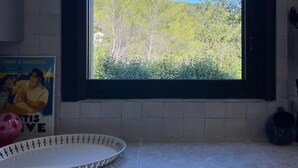 A kitchen with a window, a poster, and a decorative tray. - Air-conditioned cottage - SPA BBQ (Aix-en-Provence)