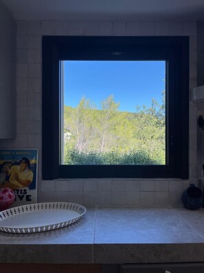 Eine Küche mit Fenster, einem Poster und einer Dekoschale.
