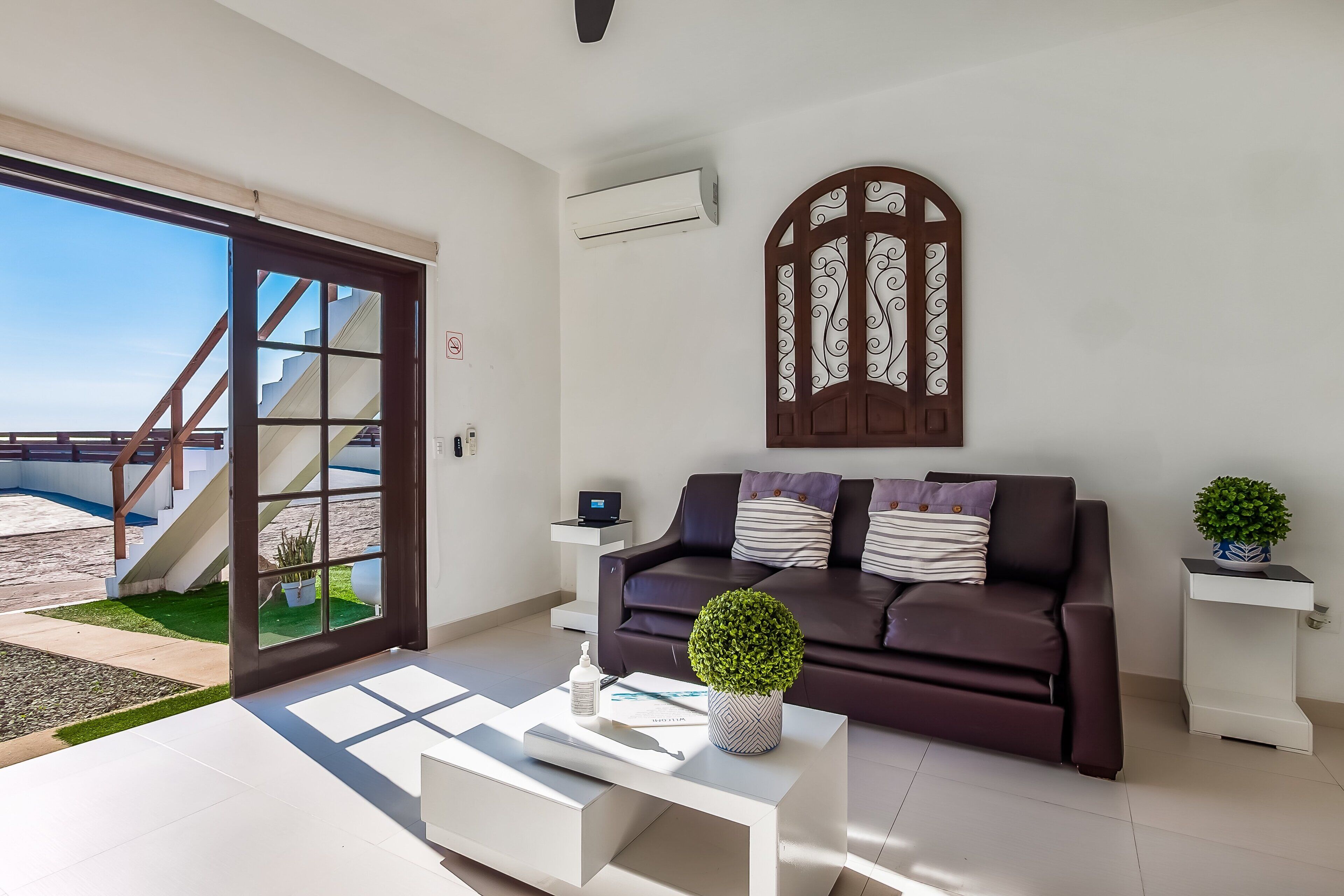 A modern living room with a sofa, coffee table, and decorative plants.