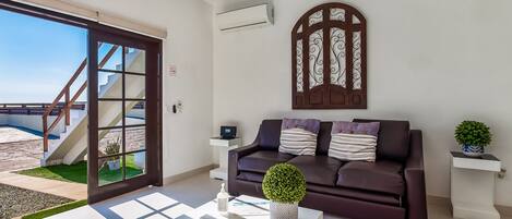 A modern living room with a sofa, coffee table, and decorative plants.