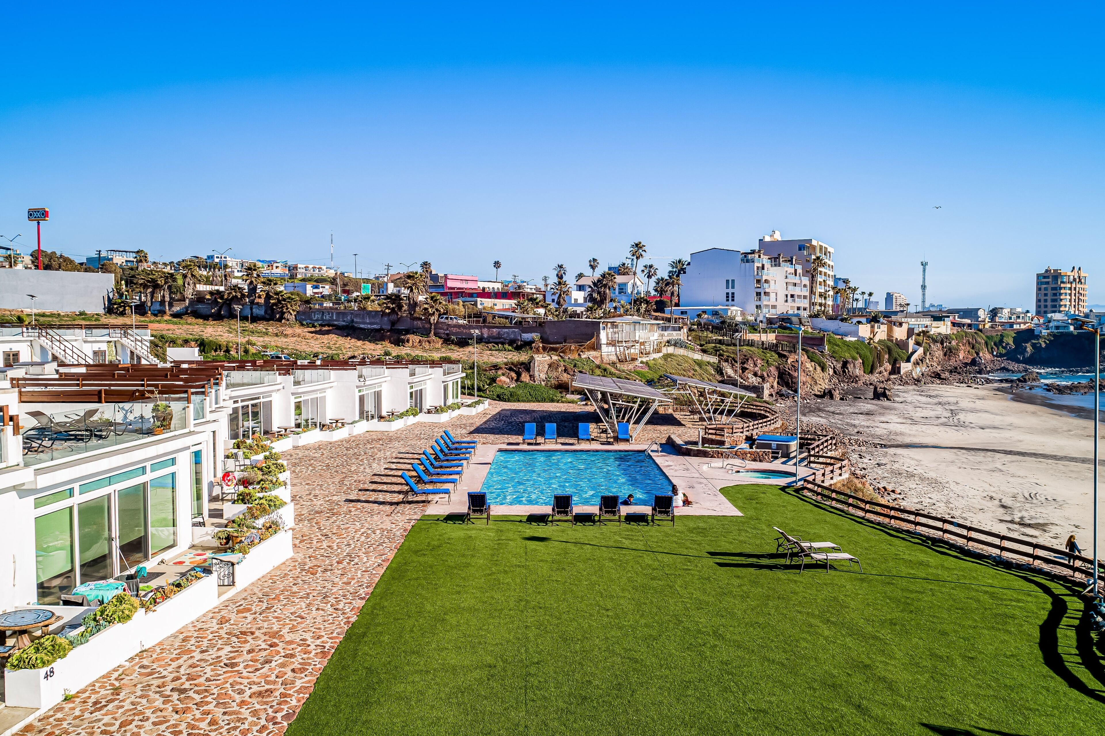 Um hotel com piscina, área de estar externa e vista para a praia.