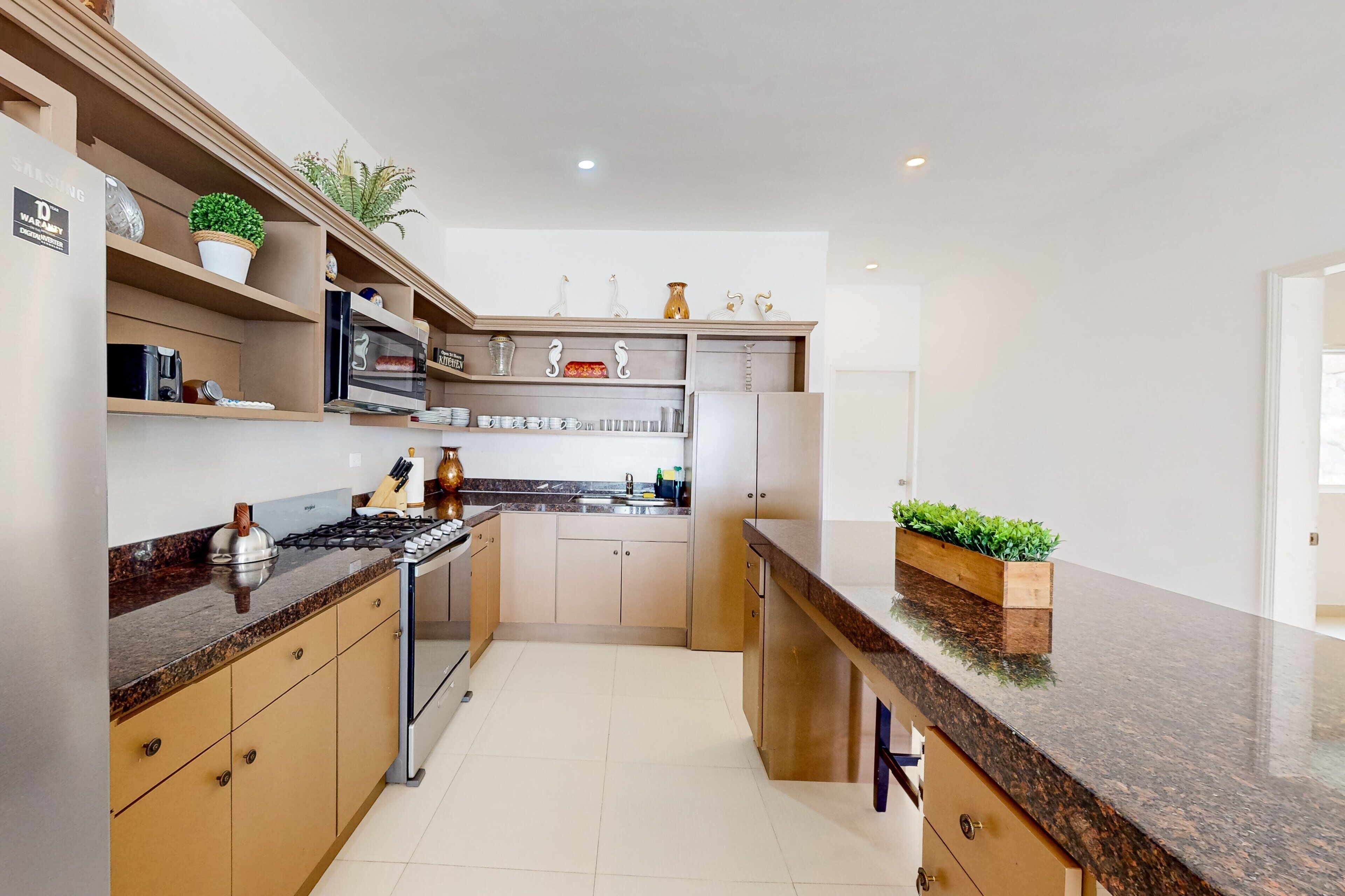 A modern kitchen with granite countertops, stainless steel appliances, and wooden cabinets.