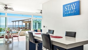 A modern kitchen with a large island, white cabinets, and a view of the outdoors. - Cheerful Dog-friendly Villa With Beach Views, Outdoor Pool, Private Patio, & AC (Playas de Rosarito)