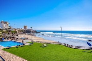 A beach resort with a swimming pool, lounge chairs, and a view of the ocean. - Cheerful Dog-friendly Villa With Beach Views, Outdoor Pool, Private Patio, & AC (Playas de Rosarito)