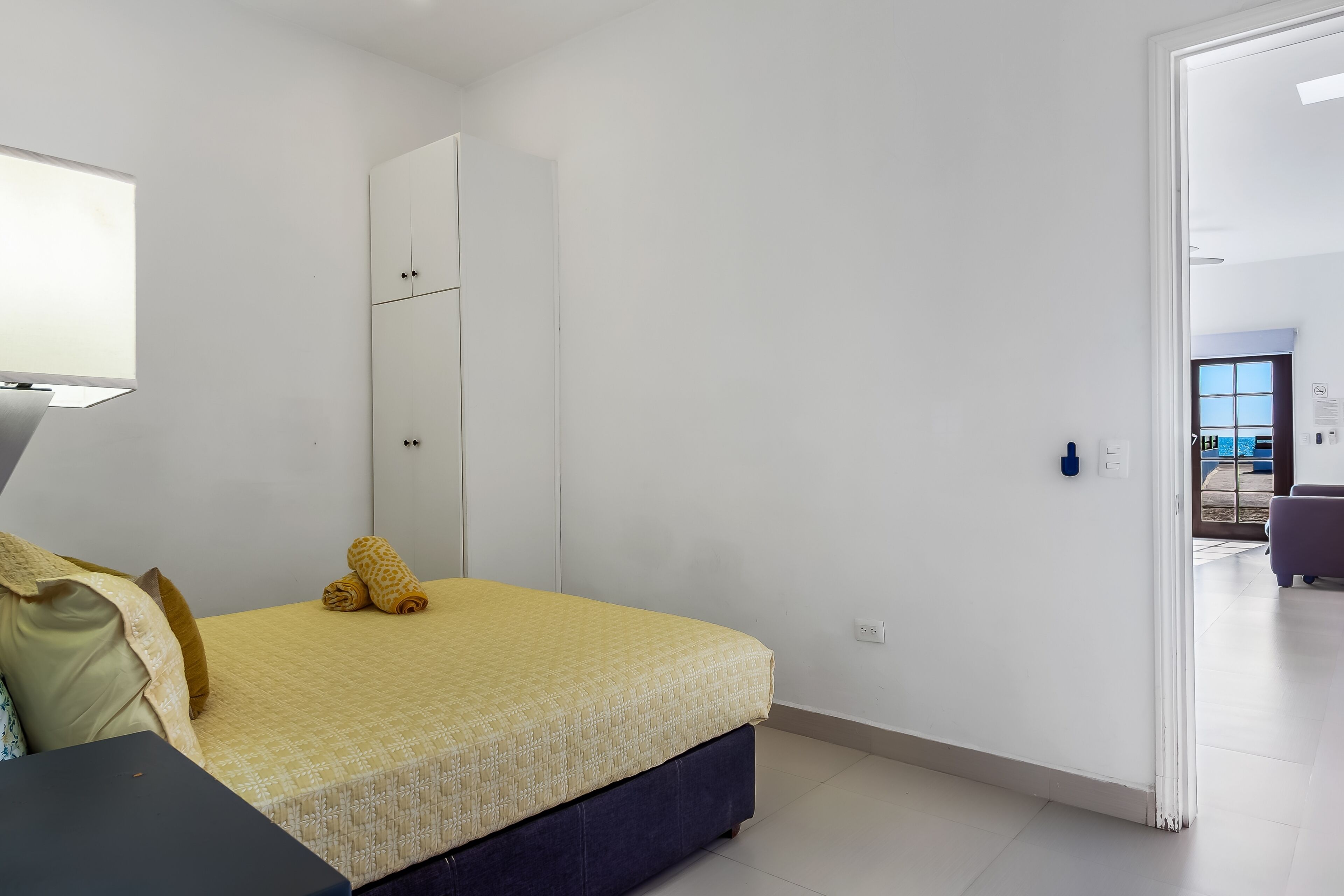 Ein Schlafzimmer mit einem Bett, einem Kleiderschrank, einem Schreibtisch und einem Stuhl.