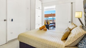 Una camera da letto con un letto, un armadio e vista sulla spiaggia.