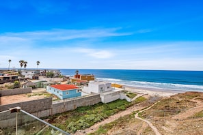 Une zone résidentielle côtière avec des maisons, une plage et un ciel dégagé.