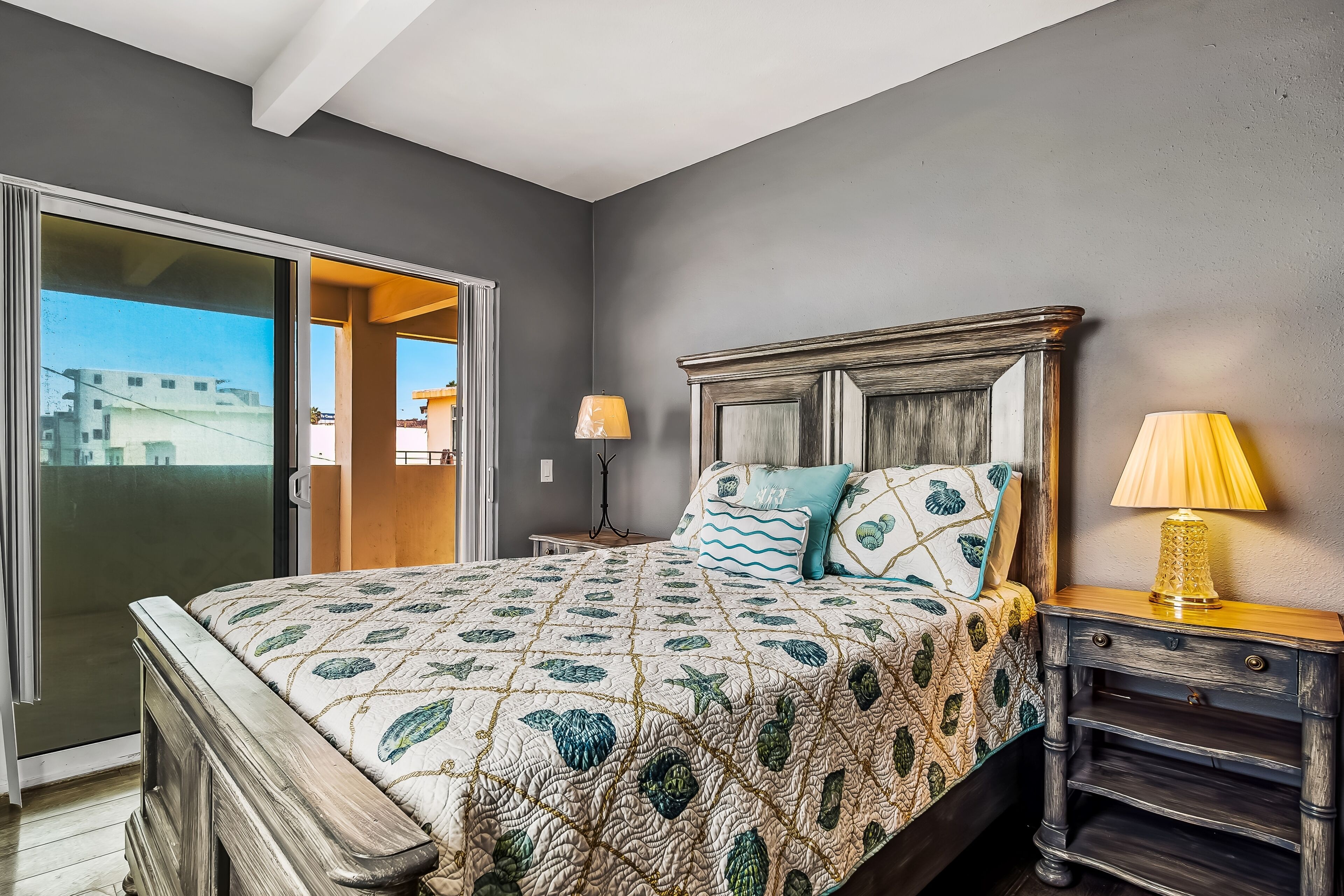 A bedroom with a bed, nightstands, and a view through a sliding door.