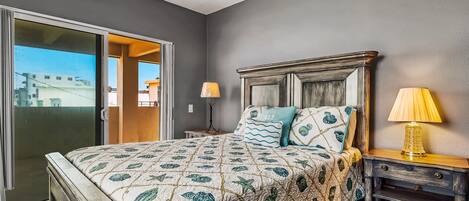 A bedroom with a bed, nightstands, and a view through a sliding door.