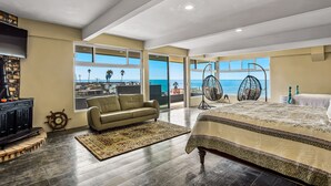 A spacious bedroom with a large bed, a sofa, and a TV. - Tropical Retreat With Ocean Views - Steps From the Sand With Alfresco Dining (Playas de Rosarito)