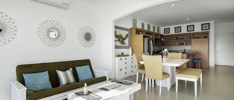Una sala de estar moderna con sofá, mesa de centro y comedor.
