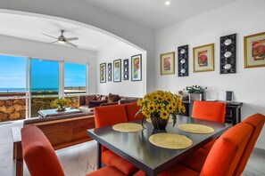 A modern dining area with a table, chairs, and artwork on the walls. - Dog-friendly Home With Partial Ocean View, Heated Pool, Rooftop Terrace (Playas de Rosarito)