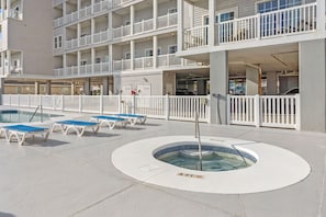 Ein Hotel mit Poolbereich, einschließlich Liegestühlen und einem Whirlpool.