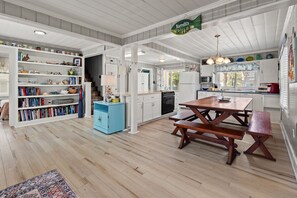 Eine geräumige Küche mit weißen Schränken, einem Holztisch und einem blauen Schrank.
