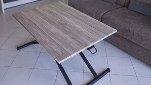 Un salon avec un canapé, une table basse, un ventilateur de plafond et un tableau encadré au mur.