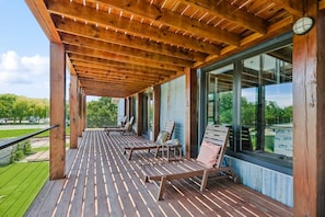 A wooden deck with outdoor seating and large windows. - Commander 6 Farragut Lofts, Old Town, City Park (Bay Saint Louis)
