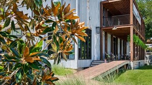 A modern two-story building with a wooden deck and outdoor seating area. - Commander 6 Farragut Lofts, Old Town, City Park (Bay Saint Louis)
