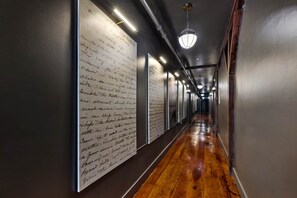 A hallway with wooden flooring and walls adorned with handwritten notes. - Commander 6 Farragut Lofts, Old Town, City Park (Bay Saint Louis)