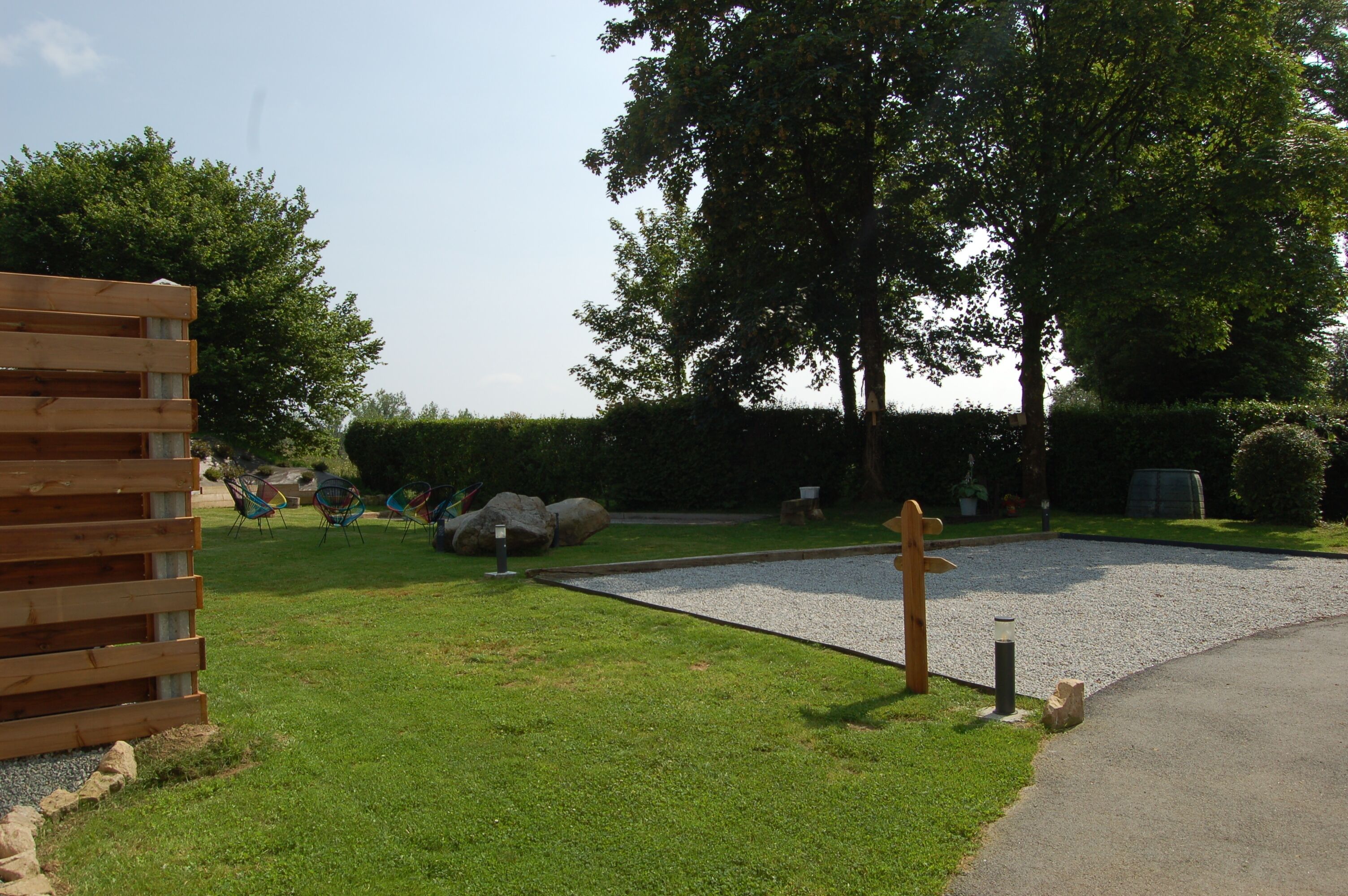 Un parc doté d’une structure en bois, d’une zone recouverte de gravier et d’un chemin pavé.