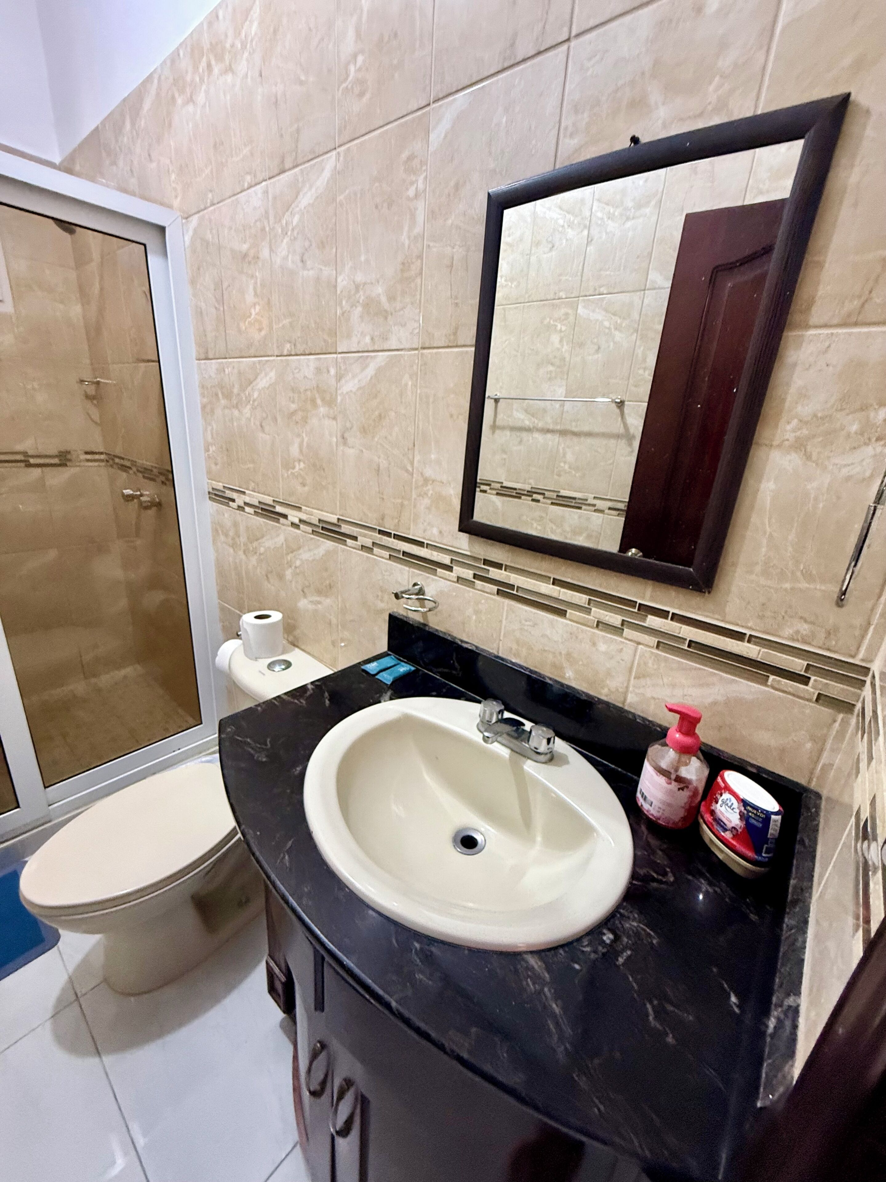 A bathroom with a sink, toilet, and shower.