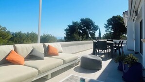 A rooftop terrace with a sofa, ottoman, and dining area. - Contemporary hillside villa with sea view (3 kms) (Xàbia)