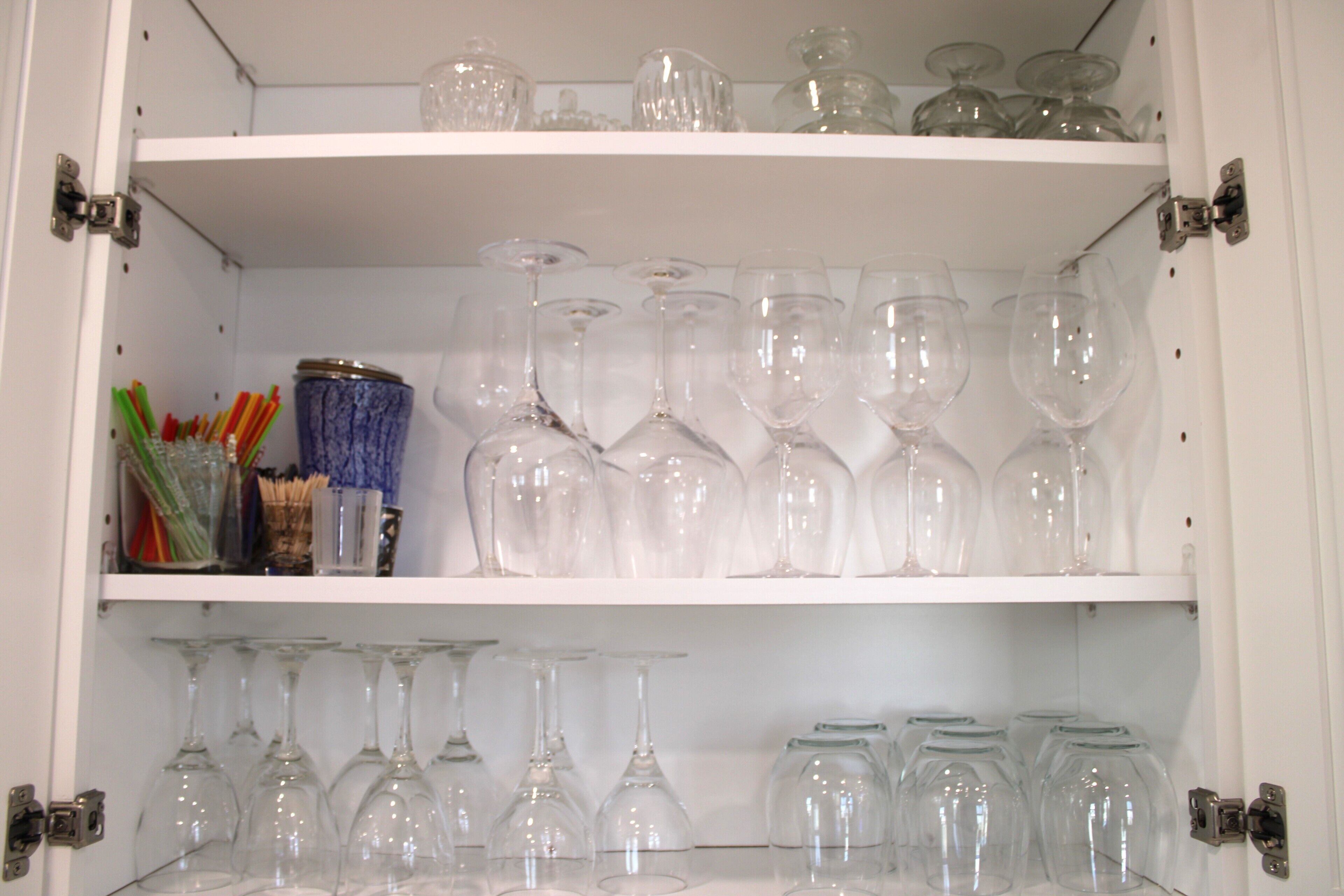 A cabinet with shelves containing wine glasses and glassware.