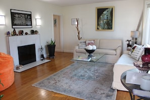 Un salon avec une cheminée, un canapé, une table basse et une table en verre.