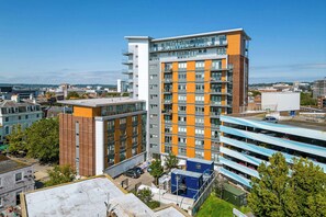 Ein mehrstöckiges Gebäude mit modernem architektonischen Design, das Backstein- und Glasfassaden kombiniert.
