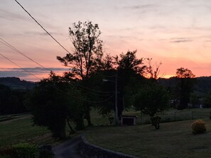Ländliche Landschaft mit einer Straße, Bäumen und einem kleinen Gebäude.