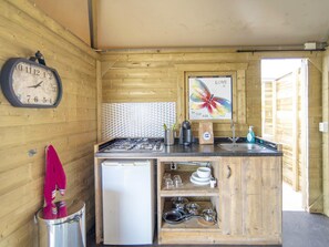 A compact kitchen with a stove, refrigerator, and a sink. There's a clock on the wall and a decorative butterfly poster. - Beachside Dune Home Retreat for 4 (Almere)