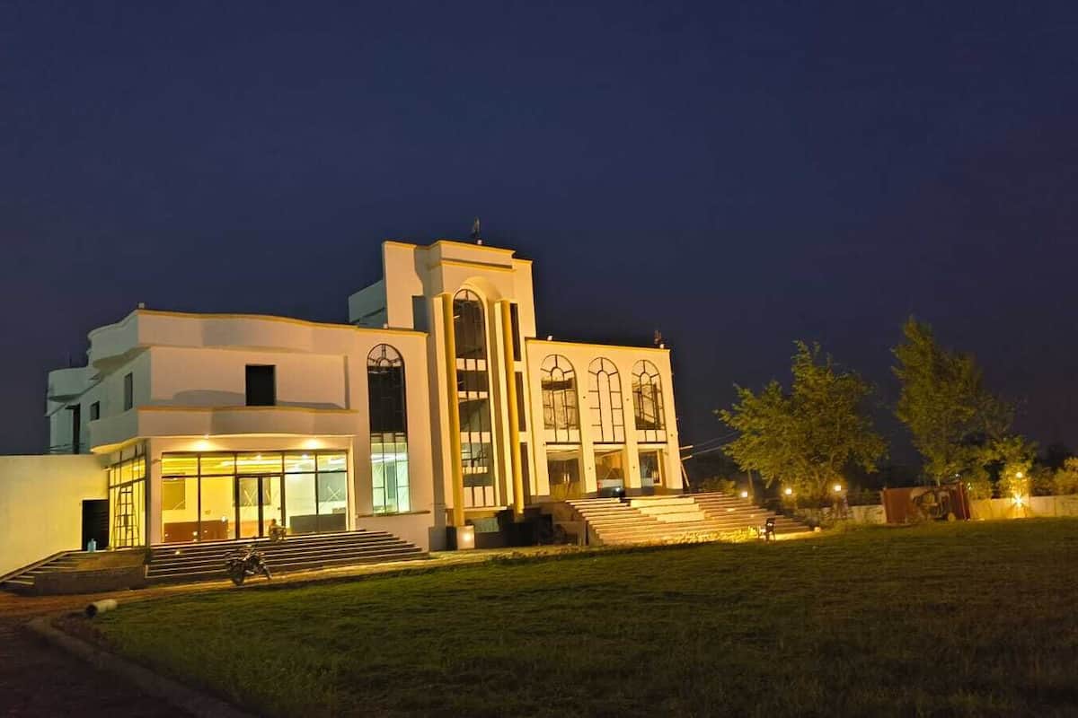 A modern building with a large entrance, steps leading up to it, and a well-lit facade.