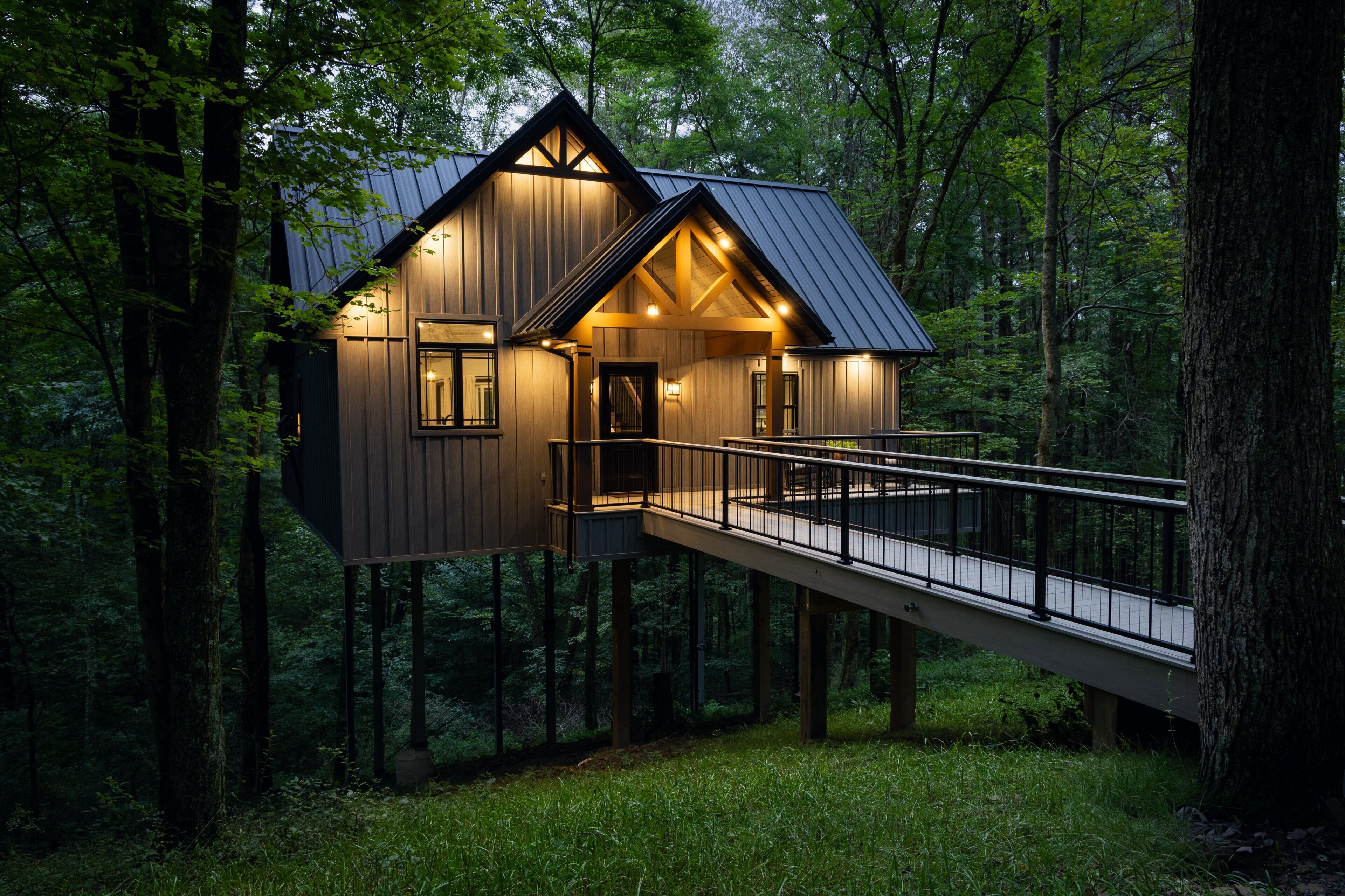 Una casa sull'albero con un balcone e una scala in metallo.