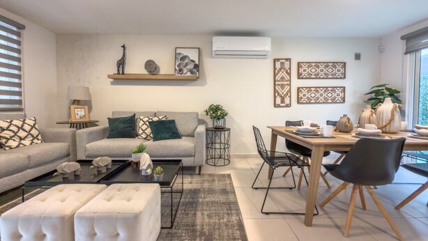 Una sala de estar moderna con sofá, mesa de centro y comedor.