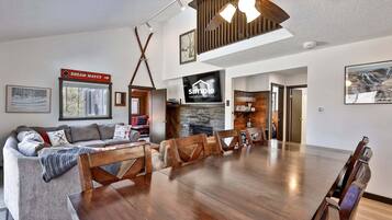 A spacious living area with a fireplace, a dining table, and a sofa.