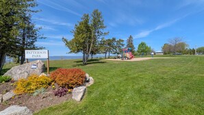 A park with a playground, a sign reading 'Patterson Park,' and a body of water in the background. - 3 Bdrm | BBQ | Fire Pit - Steps to Waterfront Park (Port McNicoll)