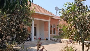 Un bâtiment à deux étages, doté d’un toit en tuiles, d’un porche couvert et d’une antenne parabolique.