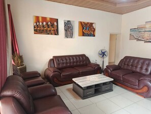 Ein Wohnzimmer mit zwei braunen Ledersofas, einem Couchtisch und Wandbildern.